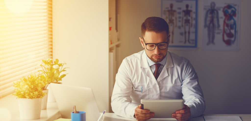 doctor in surgery reviewing using a tablet